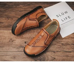 Gedetailleerde close-up van handgestikte bruine leren loafers voor heren op hout
