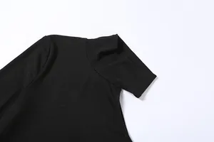 Detail view of a black ribbed knit turtleneck bodysuit with high-quality fabric texture