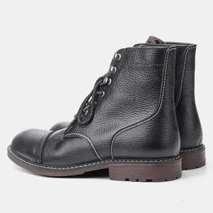 Perfil lateral de botas de trabajo de cuero vacuno negro con detalles de costuras blancas