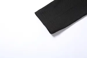 Detailed macro view of black ribbed knit bodysuit sleeve cuff with durable stitching