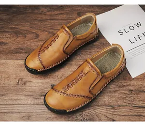 Detailopname van handgestikte bruine heren loafers van leer in een ontspannen vrijetijdssetting.