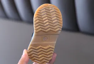 Gros plan détaillé montrant la texture de la semelle en gomme des chaussures bébé