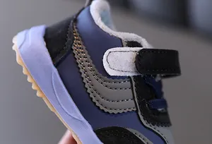 Gros plan de baskets d'hiver pour bébés, doublées de polaire chaude avec velcro et coutures.