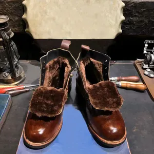 Detalle de botas de moto de cuero retro con forro de piel sintética marrón para el invierno.