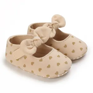 Detail view of soft cotton baby walking shoes with heart pattern and large decorative bow.