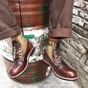 Primer plano de botas de moto vintage desgastadas combinadas con pantalones de trabajo