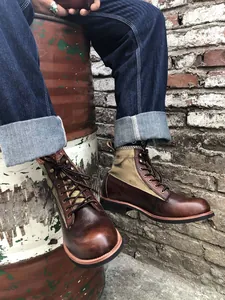 Vista detallada de las botas de moto Amekaji vintage de cuero marrón y lona en un barril