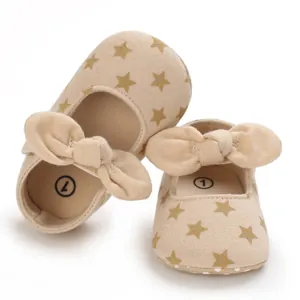 Close-up view of baby girl soft sole cotton walking shoes with star pattern and bow.
