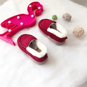 Gemütliche rote Kinder-Winterschuhe mit weichem weißem Fleece-Futter auf Teppich.