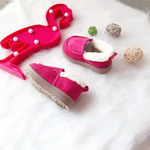 Gemütliche rosa Kinderwinterstiefel mit weichem weißem Kunstfellfutter auf Teppich.