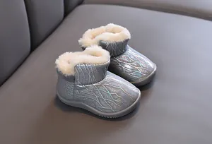 Close-up of warm children's snow boots with silver glitter pattern and faux fur lining
