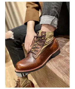 Primer plano de botas de moto retro en cuero marrón con detalles de lona y costuras