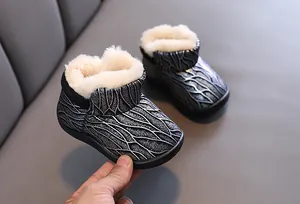 Close-up of children's fleece-lined snow boots with metallic pattern and warm faux fur