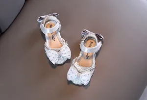 Detailed view of sparkling girls' silver princess sandals with rhinestone bowknots.
