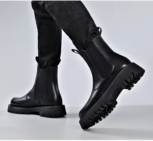 Makroansicht schwarzer Chelsea-Boots aus Leder mit Plateausohle und elastischem Einsatz.