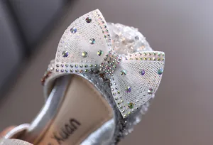 Close-up of sparkling rhinestone bow detail on silver girls' princess sandals