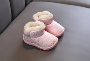 Close-up detail of pink toddler winter snow boots with warm plush white faux fur lining