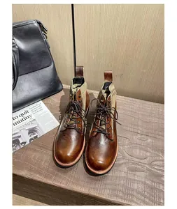 Vista superior de botas de cuero marrón vintage con cordones y detalles de lona resistente