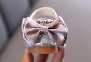 Detail of girls princess shoes featuring a large satin bow and sparkling rhinestones