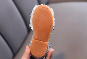 Detailed view of non-slip soft sole for girls' rhinestone sandals.