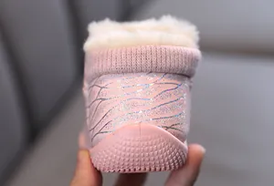 Close-up of pink children's snow boot heel with glitter butterfly wing pattern