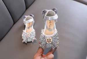 Detailed close-up of sparkling silver girls princess shoe decorated with a rhinestone bow