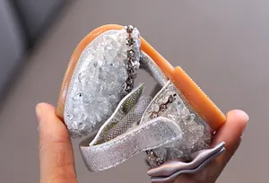 Close-up of flexible soft sole on sparkling silver girls' rhinestone princess sandals