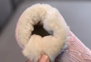 Close-up detail of the thick white plush lining in pink glitter butterfly snow boots