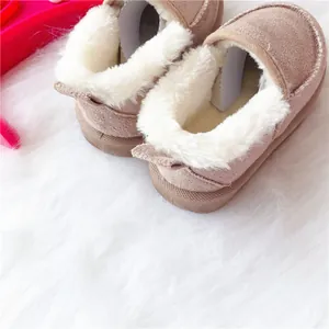 Detailansicht von Kinder-Winterstiefeln mit weichem weißem Kunstfellfutter und Wildleder.
