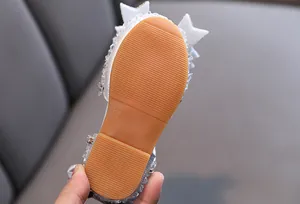 Detailed view of the non-slip tan rubber sole on girl's rhinestone bow princess sandals