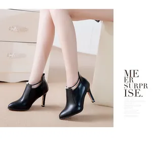 Elegantes botines de cuero negro con punta fina, tacón alto y detalle decorativo de metal