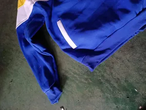 Detail of a color-block blue and yellow hoodie with ribbed cuffs and pocket detail.