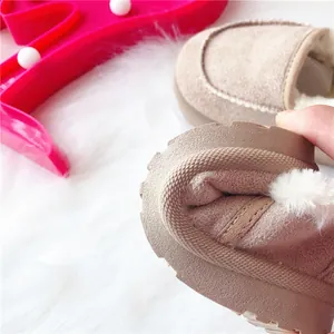 Nahaufnahme der flexiblen dicken Gummisohle und des warmen Kunstfellfutters bei Kinderwinterstiefeln