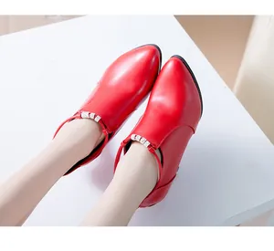 Vista detallada de botas de cuero rojas de punta con acentos de correas de cristal brillantes
