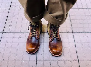Primer plano de botas de moto de cuero marrón vintage con puntera bruñida y cordones