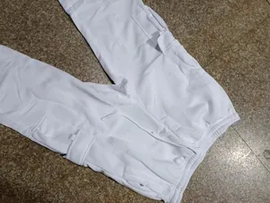 Close-up detail of white men's casual cargo pants featuring a drawstring waist and side pockets.