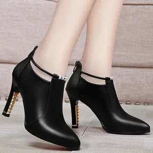 Elegantes botines negros de punta fina con tacones de aguja decorados con tachuelas