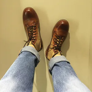 Vista POV de botas de moto retro japonesas de cuero y lona en marrón envejecido