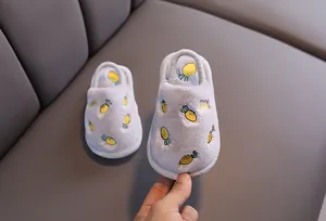 Détail de chaussons en peluche pour enfants avec broderie ananas et bride arrière