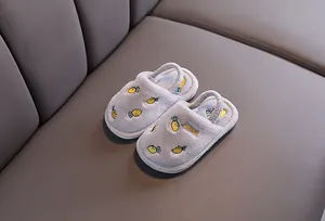 Gros plan de chaussons en peluche gris pour bambins avec broderie carotte mignonne