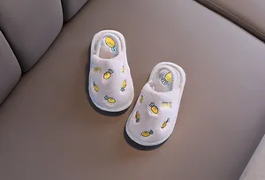 Détail de chaussons en peluche pour enfants avec broderie ananas et doublure douce