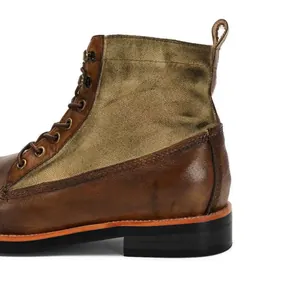 Primer plano de bota de moto vintage de cuero y lona que muestra detalles del talón