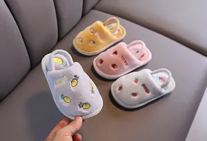 Gros plan de pantoufles en peluche pour enfants avec de jolis motifs de fruits de dessin animé