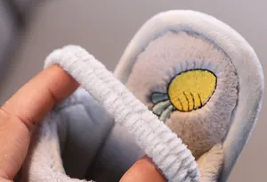 Gros plan détaillé de chaussons en peluche pour enfants avec bride élastique et carotte
