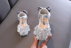 Close-up of sparkling rhinestone butterfly detail on silver princess shoes for girls