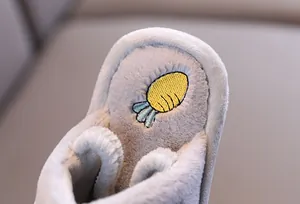 Vue détaillée de la peluche grise douce et de la broderie de carotte sur le chausson