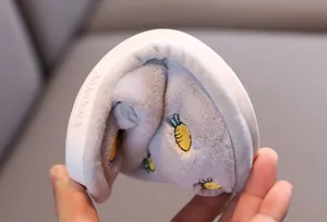 Vue détaillée d'un chausson gris flexible pour enfant avec motif carotte brodé