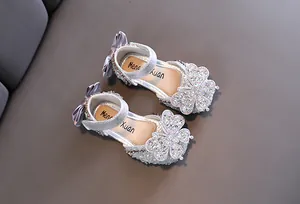 Close-up of silver girls princess sandals featuring sparkling rhinestone butterfly bows.