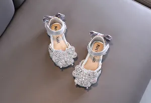 Detail of silver girls' princess sandals with sparkly rhinestone butterflies and bows