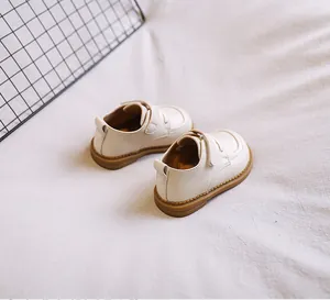 Detailed close-up view of cream soft-sole baby leather walking shoes with Velcro straps.